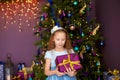 Girl with gift box near christmas tree Royalty Free Stock Photo