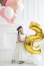 Vertical portrait of a cute five year old girl in a white studio Royalty Free Stock Photo