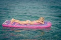 Cute girl lying on inflatable pink airbed and sunbathing Royalty Free Stock Photo