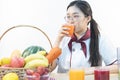 A cute girl makes vegetable juice, with carrot apple orange cranberry beetroot and mango in chef suit Royalty Free Stock Photo