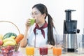 A cute girl makes vegetable juice, with carrot apple orange cranberry beetroot and mango in chef suit Royalty Free Stock Photo