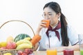 A cute girl makes vegetable juice, with carrot apple orange cranberry beetroot and mango in chef suit Royalty Free Stock Photo