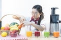 A cute girl makes vegetable juice, with carrot apple orange cranberry beetroot and mango in chef suit Royalty Free Stock Photo