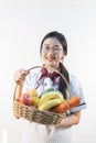 A cute girl makes vegetable juice, with carrot apple orange cranberry beetroot and mango in chef suit Royalty Free Stock Photo