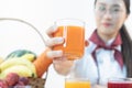 A cute girl makes vegetable juice, with carrot apple orange cranberry beetroot and mango in chef suit Royalty Free Stock Photo