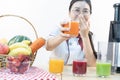 A cute girl makes vegetable juice, with carrot apple orange cranberry beetroot and mango in chef suit Royalty Free Stock Photo