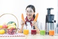 A cute girl makes vegetable juice, with carrot apple orange cranberry beetroot and mango in chef suit Royalty Free Stock Photo