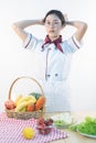 A cute girl makes vegetable juice, with carrot apple orange cranberry beetroot and mango in chef suit Royalty Free Stock Photo