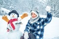 Cute girl making snowman on snowy field outdoor. Joyful Beauty young woman Having Fun in Winter Park. Royalty Free Stock Photo