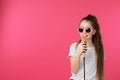 Cute girl with microphone on color background
