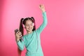 Cute girl with mobile phone enjoying music in headphones on color background Royalty Free Stock Photo