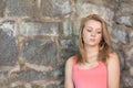 Cute girl with old stone wall in background