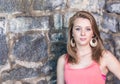 Cute girl with old stone wall in background