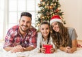 Cute girl opening a magical present on a Christmas morning with her family Royalty Free Stock Photo