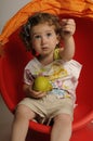 Cute girl with pear sitting on red Chair