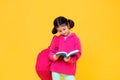 Cute girl with pigtail hair reading a book