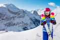 Cute girl in pink helmet hold crossed pair of ski Royalty Free Stock Photo