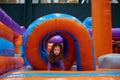 Cute girl playing on inflatable bounce house in entertainment center Royalty Free Stock Photo
