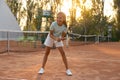 Cute little girl playing tennis on court outdoors Royalty Free Stock Photo