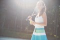 Cute girl playing tennis and posing for the camera.