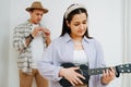 Cute girl playing ukulele in the background of a man playing the Irish flute Royalty Free Stock Photo