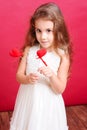 Cute girl playing with valentines hearts on red Royalty Free Stock Photo