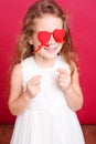 Cute girl playing with valentines hearts on red Royalty Free Stock Photo