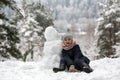 Cute girl posing with snowman in winter snowy Park Royalty Free Stock Photo