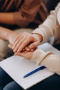 A cute girl at a psychologist's appointment. Psychologist woman holding her patient's hands