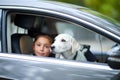 A cute girl with puppy in the black car. Pet concept. Royalty Free Stock Photo