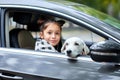 A cute girl with puppy in the black car. Pet concept. Royalty Free Stock Photo