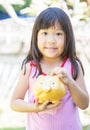 Cute girl put coin to piggy bank. Royalty Free Stock Photo