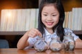 Cute girl putting money coins in glass,saving money concept Royalty Free Stock Photo