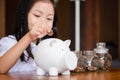 Cute girl putting money coins in piggy bank,saving money concept Royalty Free Stock Photo