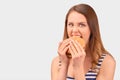 Cute girl quickly eats Burger, wrinkling nose Royalty Free Stock Photo