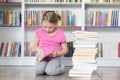 Cute girl reading book in library Royalty Free Stock Photo