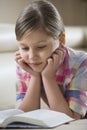 Cute girl reading book while lying at home Royalty Free Stock Photo