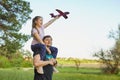 Cute girl riding on father`s shoulder and playing with toy airplane Royalty Free Stock Photo