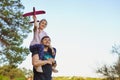 Cute girl riding on father`s shoulder playing with toy airplane Royalty Free Stock Photo