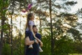 Cute girl riding on father`s shoulder and playing with toy airplane Royalty Free Stock Photo