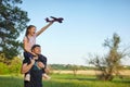 Cute girl riding on father`s shoulder playing with toy airplane Royalty Free Stock Photo