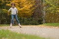 Cute girl roller skating in autumn park Royalty Free Stock Photo