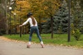 Cute girl roller skating in autumn park Royalty Free Stock Photo