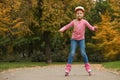 Cute girl roller skating in autumn park Royalty Free Stock Photo