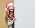 Cute girl in Santa hat looks with surprise at the place for the text. christmas and new year advertising concept