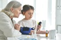 Cute girl and senior woman measuring blood pressure