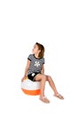 Cute girl sitting on beach ball waiting to play Royalty Free Stock Photo