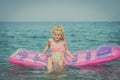 Cute girl sitting on inflatable pink airbed Royalty Free Stock Photo