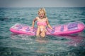 Cute girl sitting on inflatable pink airbed Royalty Free Stock Photo