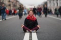 Cute girl sitting in meditation in the middle of a busy street.